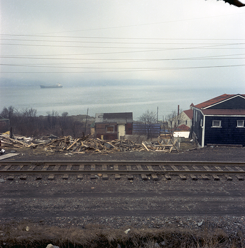 Colour photo of house with a demolished structure beside it.