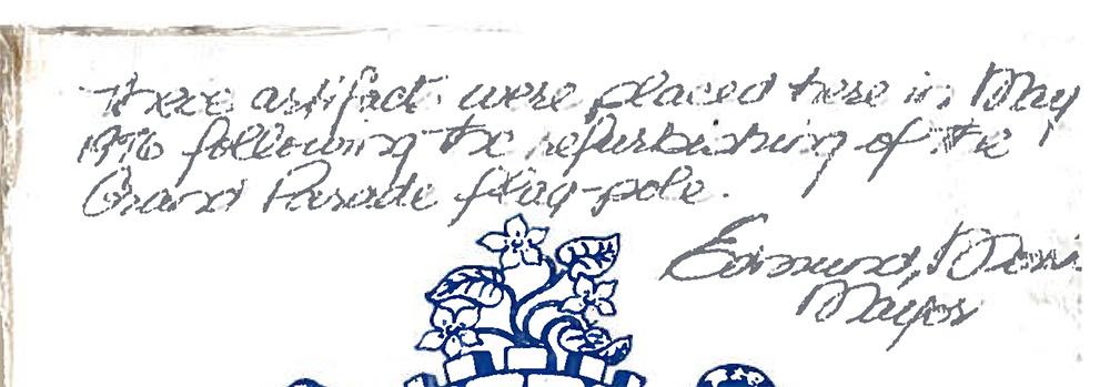 Note reading “These artifacts were placed here in May 1976 following the refurbishing of the Grand Parade flag pole” by Edmund Morris, Mayor.