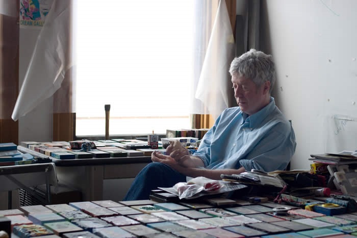 A photo of the artist working on the paintings that have been installed in the Halifax Central Library