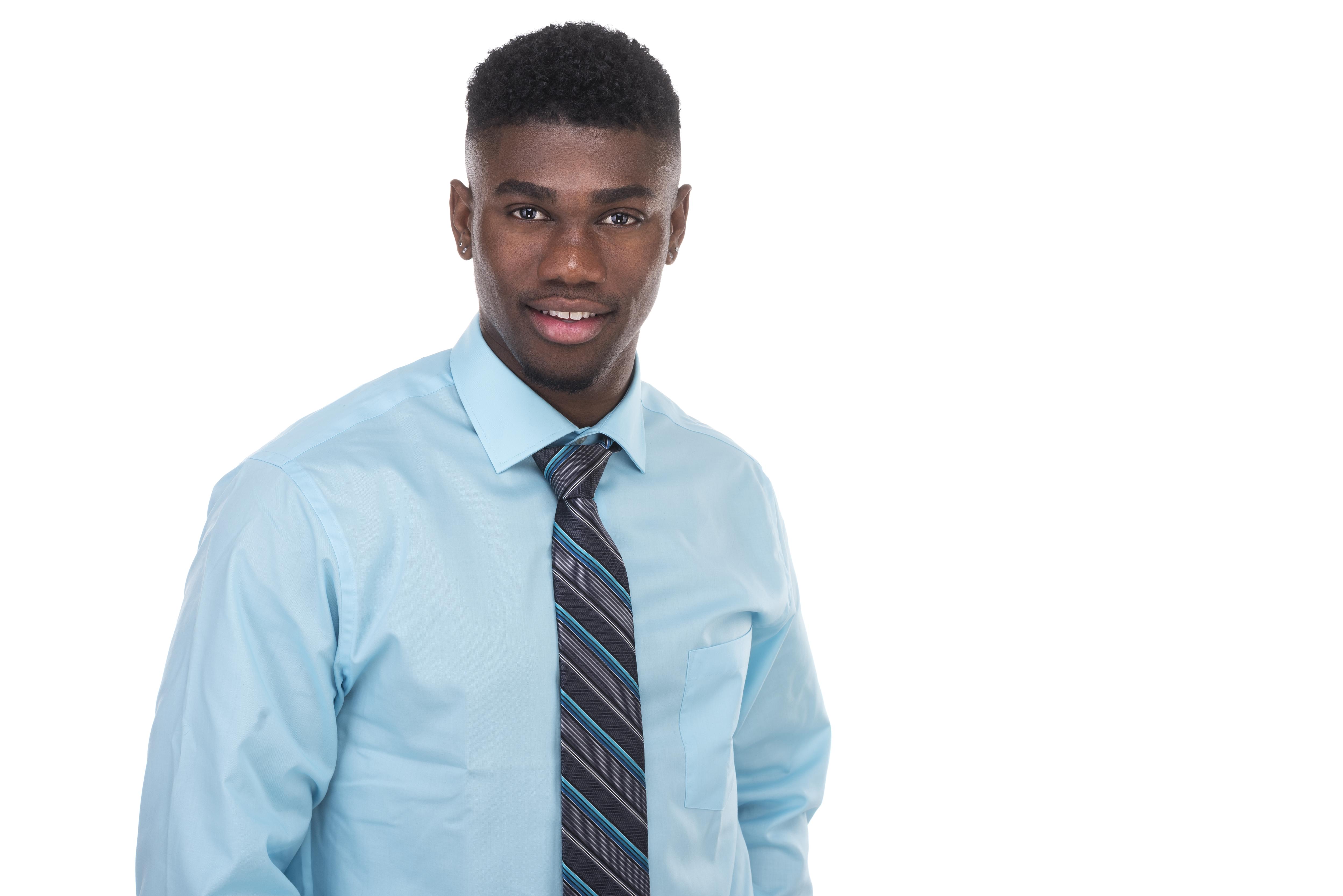 Photo of Carlos Beals, wearing a blue shirt and striped tie, smiling