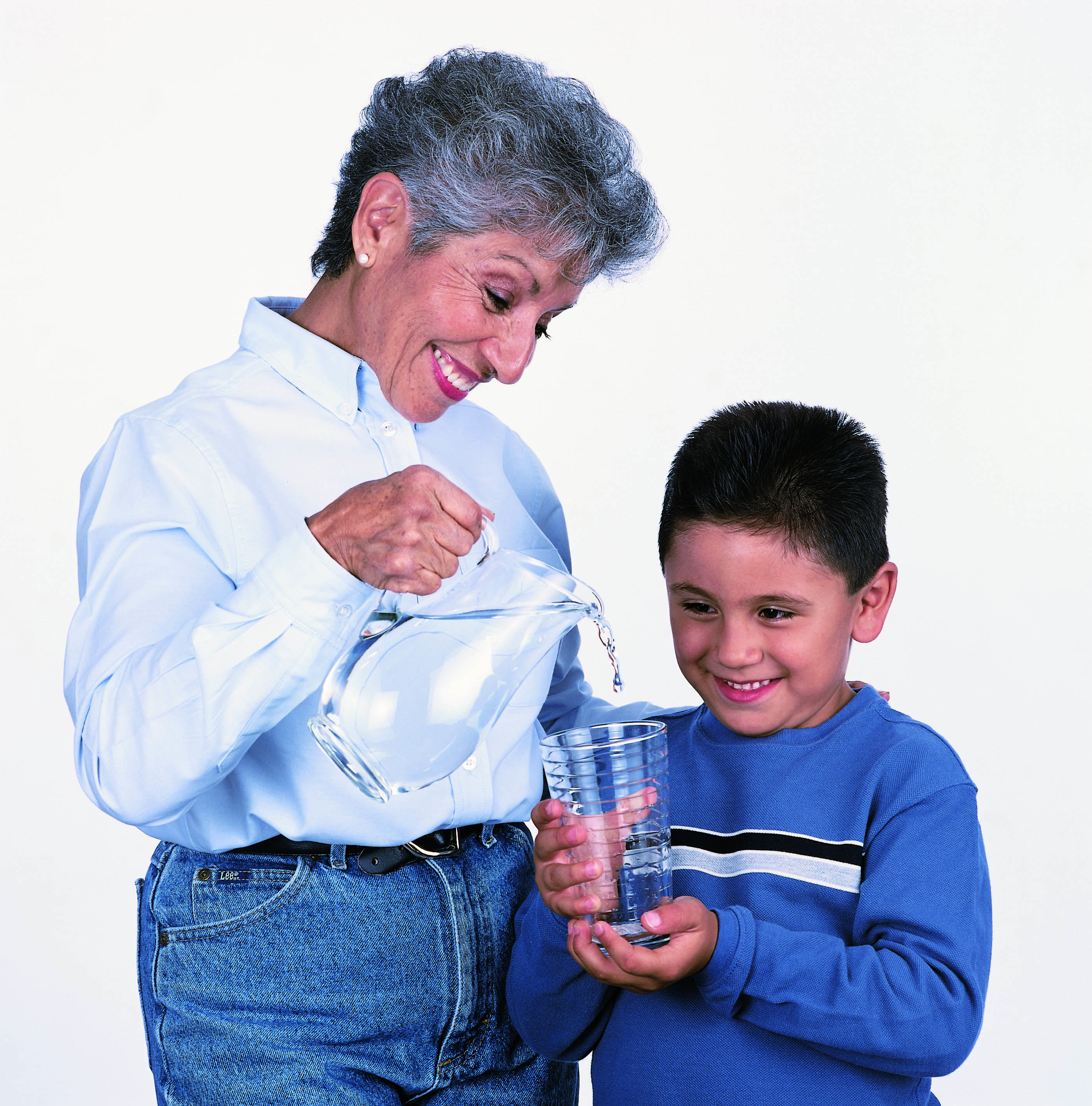 Woman filling a glass of clean water for her grandson