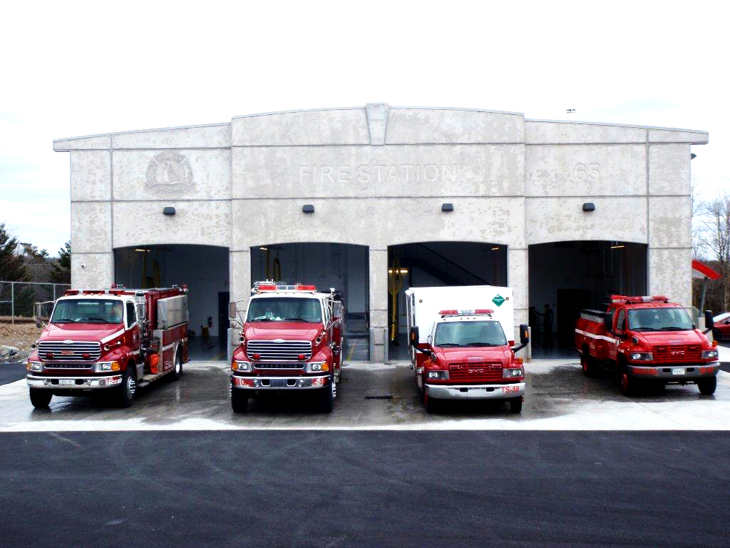A photo of fire fighting vehicles outside of a fire station