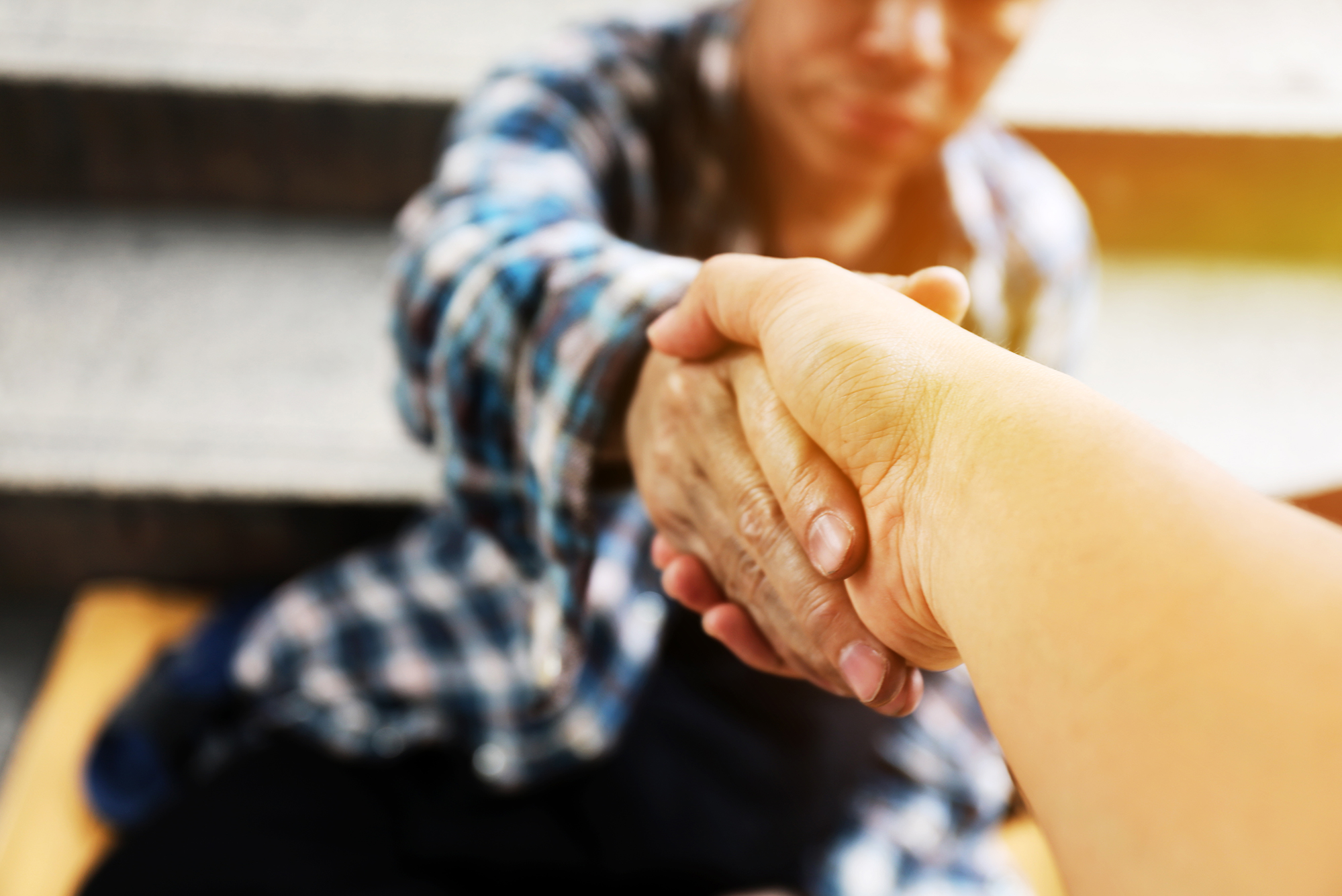 A photo of one person reaching out and shaking hands with another