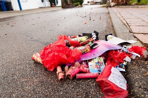 Fireworks litter on the side of a residential street.
