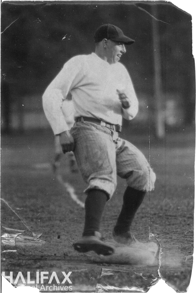 Black and white photograph of a baseball player running to a base