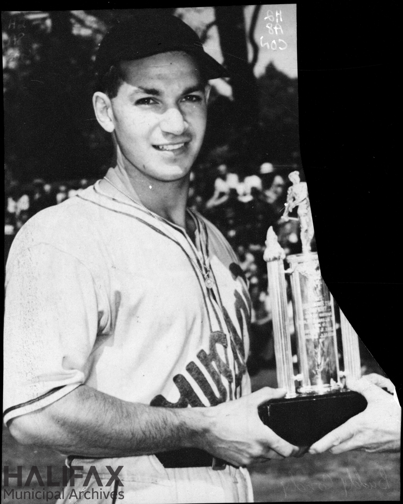 Black and white image of a baseball player holding a trophy
