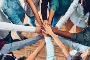 A group of people with their hands in a circle
