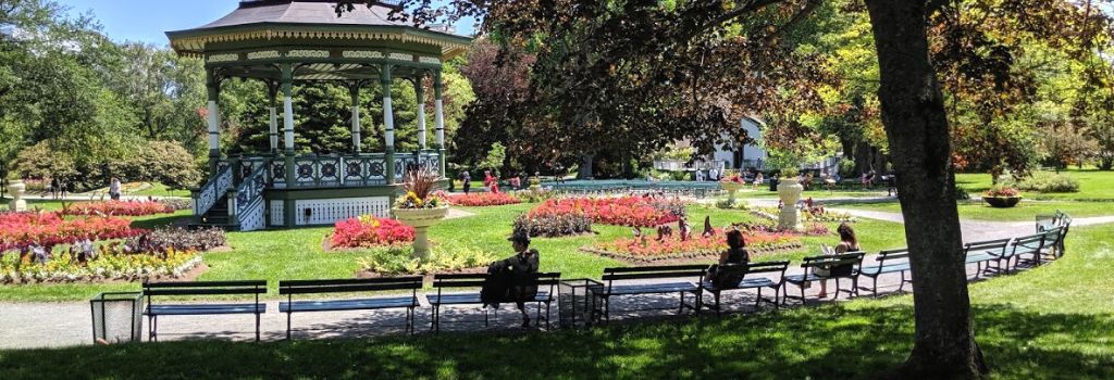 People sitting on benches around the gazebo at the Halifax Public Gardens