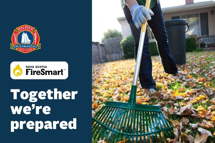 The lower half of a person is picture racking leaves in their front yard.