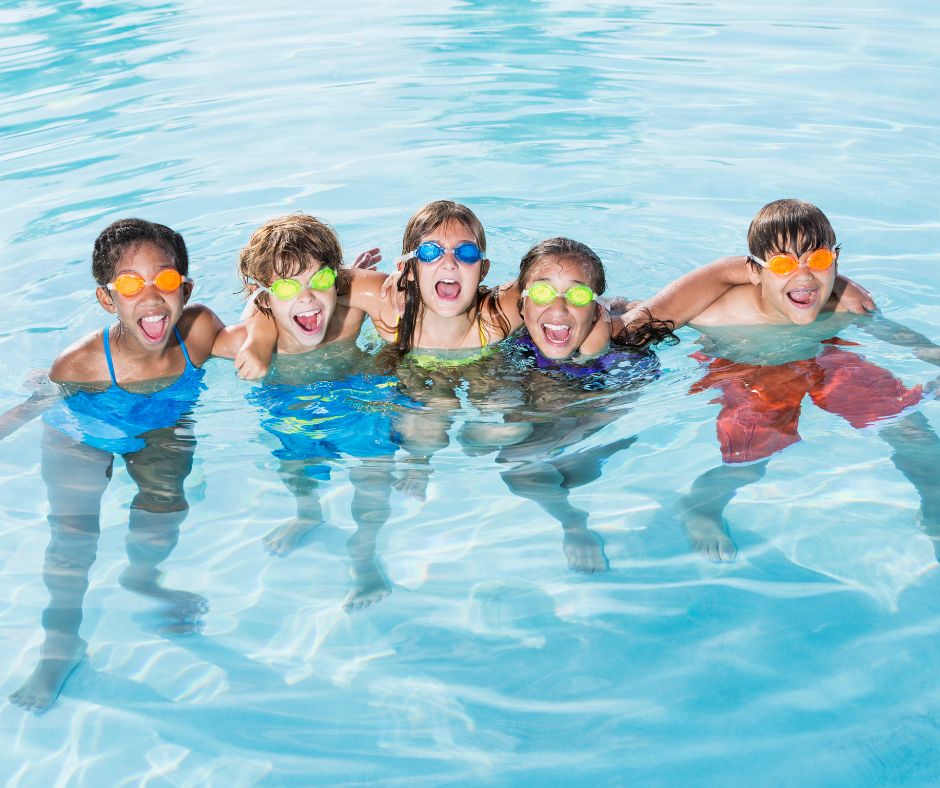 five kids playing in an outdoor pool