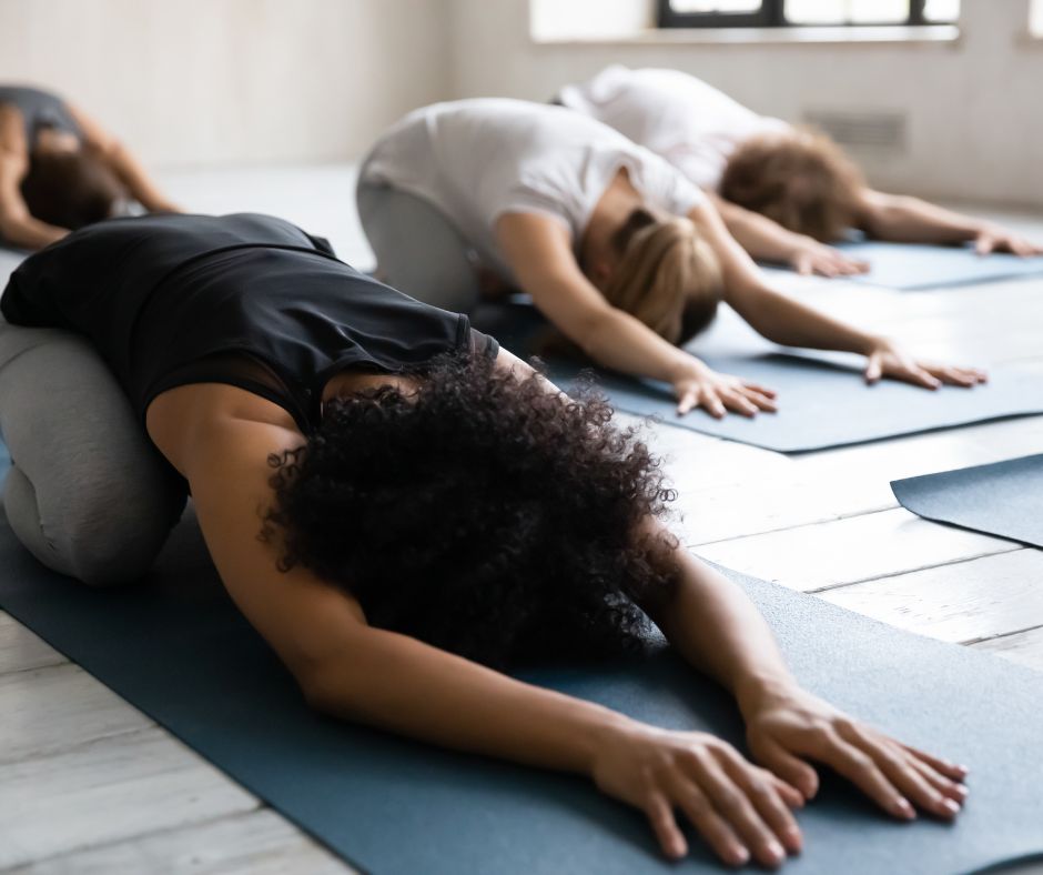 a room of people doing restorative yoga on their mats