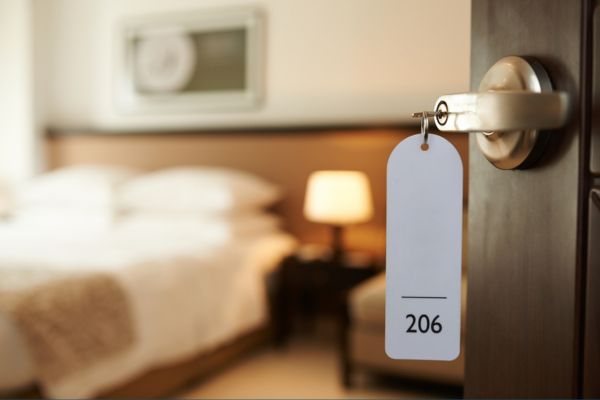 Hotel door open with a view of a hotel room.
