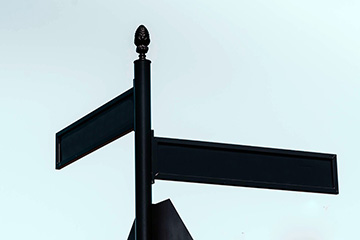 An image of two intersecting street signs at an intersection. They are both shaded.