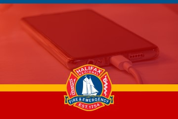 A mobile phone pulled in on a hard surface charging.