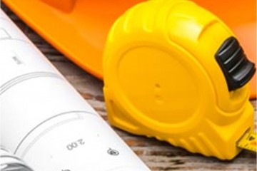Measuring tape hard hat and building plans