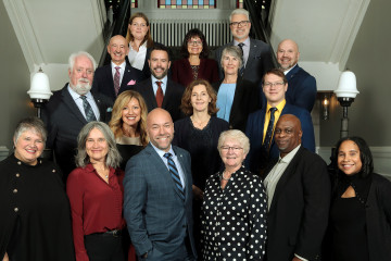 Members of Regional Council stand together on the staircase inside City Hall