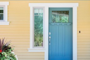 exterior of yellow house with blue door 