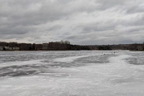 frozen ice on Lake Banook with skaters off in the distance