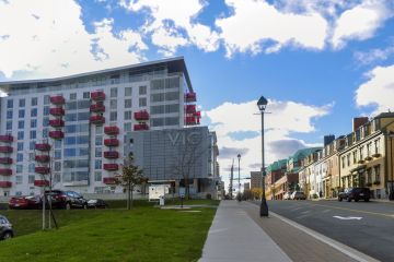the Vic apartment building, a park space, and heritage homes on Morris Street