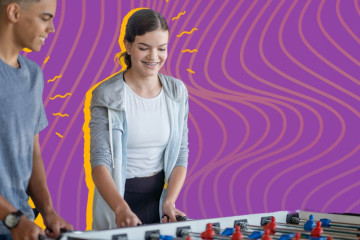 Two youth are playing fooseball